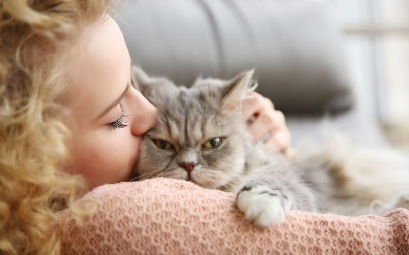 woman snuggling a cat